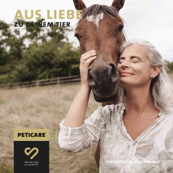 Eine Frau berührt sanft das Gesicht eines braunen Pferdes auf einer grasbewachsenen Fläche. Der Text lautet "AUS LIEBE ZU DEINEM TIER" und "PETICARE® FÜR DIE LIEBE ZU DEINEM HAUSTIER."