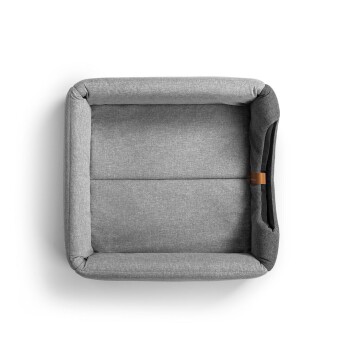 Graues Haustierbett mit einer weichen Stofftextur, in quadratischer Form und mit einem Lederetikett an der Seite.