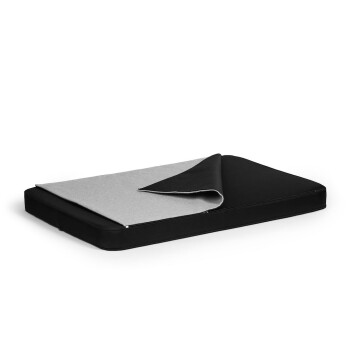 Ein schwarzes Haustierbett mit einer grauen, umkehrbaren oberen Schicht, die teilweise zurückgeklappt ist und das zweifarbige Design zeigt.