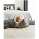 Ein flauschiger orangefarbener Pomeranian-Hund sitzt bequem in einem stilvollen grauen Haustierbett, mit einer gemütlichen Schlafzimmerumgebung im Hintergrund.
