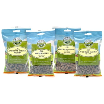 Mix 4 Soft-snacks - Freiland-Happen 200g + Heide-Happen 200g + Wildbach-Happen 200g + Landgut-Happen 200g Vier Beutel mit Tierleckerlis, die mit verschiedenen Geschmacksrichtungen beschriftet sind: Insekten, Lamm, Huhn und Lachs, mit weichen Snacks für Haustiere.