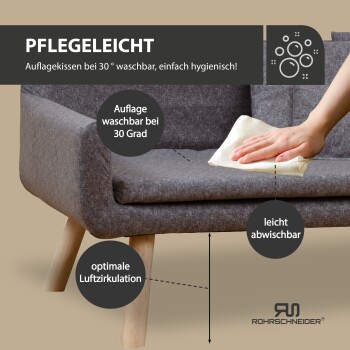 Ein gemütliches graues Haustiersofa mit einem entspannten Golden Retriever darauf, mit zwei kleinen Kissen und Holzbeinen, vor einer hellen Wand.