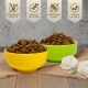 Zwei Schalen mit Futter – gelb und grün – neben weißen Seilspielzeugen. Highlights: getreidefrei, hoher Proteingehalt, kein Zuckerzusatz, Vitamine A, E, D3.
