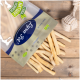 Ein Sack "Premium Qualität" Tierleckerlis mit einem "100% Natürlich"-Siegel, der leichte Kausticks neben einem weißen Seilspielzeug auf Holz auskippt.
