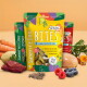Drei bunte SmoothieDog BITES gefriergetrocknete Snack-Beutel (Huhn), umgeben von Fleisch, Früchten, Gemüse und Samen.