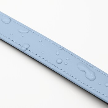 Eine Nahaufnahme einer hellblauen Haustierleine mit Wassertropfen auf der Oberfläche, die das wasserdichte Material und die Nähdetails zeigt.