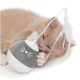 Un chaton de couleur claire et joueur mordille un jouet interactif rond, blanc et gris avec une plume attachée, conçu pour le divertissement des animaux de compagnie.
