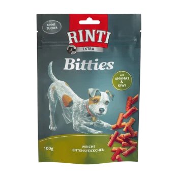Die Verpackung von Rinti Bitties Hundeleckerlis zeigt einen verspielten Hund, beschriftet mit "Ohne Zucker" und "mit Ananas & Kiwi."