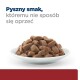 Biała miska wypełniona wilgotnymi, brązowymi granulkami karmy dla zwierząt, z towarzyszącym tekstem 'Pyszny smak, któremu nie sposób się oprzeć' w niebieskim i szarym.