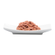 Ein Haufen rosa Haustierfutter auf einem weißen Teller, der eine weiche, strukturierte Konsistenz zeigt.