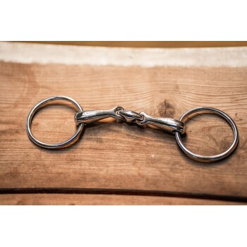 Ein glänzendes Metall-Pferdegebiss mit zwei Ringen, das auf einer Holzoberfläche liegt. Das Gebiss ist mit "EQUITANA" graviert.