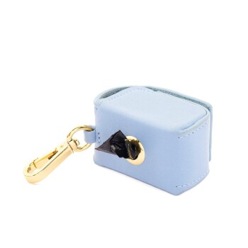 Hellblauer Abfallbeutelspender für Haustiere mit einem goldenen Clip, mit einem schwarzen Abfallbeutel, der teilweise aus der Öffnung sichtbar ist.