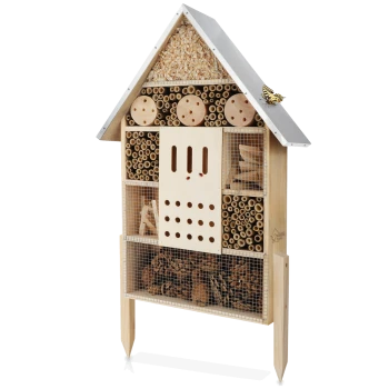 Holzinsektenhotel in Form eines Hauses, mit verschiedenen Fächern, die mit natürlichen Materialien für nützliche Insekten gefüllt sind.