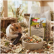 Nahaufnahme eines Meerschweinchens neben einer grünen Schüssel mit gemischtem Haustierfutter und einer Tüte mit der Aufschrift "PANTO Naturgenuss" mit Bildern von kleinen Tieren.