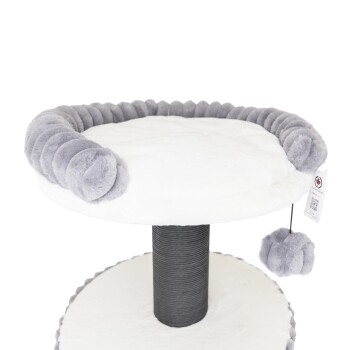 Ein plüschiger Katzenbaum mit einer weichen weißen Oberseite und einem grauen Pom-Pom-Rand, mit einem hängenden grauen Pom-Pom-Spielzeug und einer stabilen schwarzen Basis.
