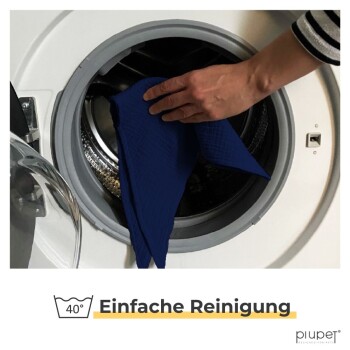 Eine Hand legt einen blauen Stoff in eine Waschmaschine, mit dem Text "40° Einfache Reinigung" darunter, was auf eine einfache Reinigung bei 40 Grad hinweist.