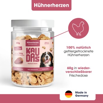 Eine Hand hält ein Hundeleckerli mit der Aufschrift "100% Hühnerherzen", "0g", "Ohne Zucker oder Zusatzstoffe", "Ideal für Training & Belohnung."