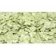 Nahaufnahme von hellgrünen, flachen Haustierfutterflocken, die über eine Oberfläche verstreut sind, um ihre Textur und Farbe zu zeigen.