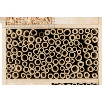Ein hölzernes Insektenhotel, gefüllt mit verschiedenen Größen von hohlen Röhren, entworfen für einsame Bienen und nützliche Insekten.