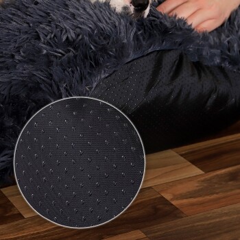 Ein gemütliches Haustierbett mit einem flauschigen navyblauen Außenmaterial und einer strukturierten schwarzen Basis, mit einer Nahaufnahme des rutschfesten Bodens.