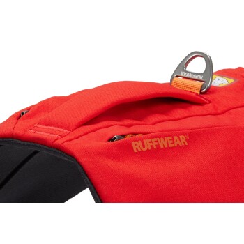 Nahaufnahme eines leuchtend roten Hundegeschirrs mit dem 'RUFFWEAR'-Logo, mit einem stabilen Griff und sichtbaren Reißverschlüssen an der Seite.