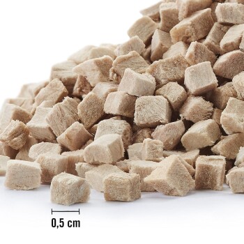 Nahaufnahme von kleinen, hellbraunen, würfelförmigen Haustierfutterstücken, die 0,5 cm messen und auf einer weißen Oberfläche gestapelt sind.