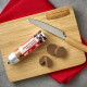 Hunde-Leckerlirolle mit aufgeschnittenen Scheiben auf einem Holzbrett und Messer; Etikett 'meat&treat', Brett graviert mit 'FLEISCHESLUST'.