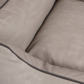 Nahaufnahme eines weichen, beigen Haustierbettes mit strukturierter Oberfläche und dunkler Einfassung entlang der Kanten, entworfen für Komfort.