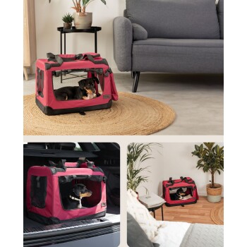 Ein kleiner Hund ruht sich in einer rosa Haustiertrage mit Netzfenstern aus, die auf einem runden Jute-Teppich in einem modernen Wohnzimmer steht.