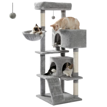 Ein mehrstöckiger grauer Katzenbaum mit drei Katzen: eine in einem hängenden Korb, eine auf einer oberen Plattform und eine in einem würfelförmigen Versteck.