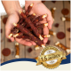 Hände halten Hundekau-Sticks mit verstreuten Leckereien im Hintergrund; ein Abzeichen liest "Beste Qualität" und "15 Jahre."