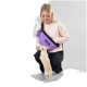 Eine Person in einem hellrosa Sweatshirt kniet auf dem Boden und interagiert mit einem kleinen beigen Hund. Sie trägt eine lila PAKKA Umhängetasche.