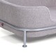Ein gemütliches graues Haustierbett mit einem weichen Stoffkissen und einem eleganten Metallrahmen, mit einem kleinen roten Logoetikett.