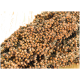 Nahaufnahme eines Bündels Hirse-Samen, die ihre runden, bräunlich-orangefarbenen Körner vor einem hellen Holz-Hintergrund zeigen.