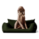 Ein hellbrauner Hund, der auf einem dunkelgrünen Hundebett aufrecht sitzt und neugierig zur Seite schaut.