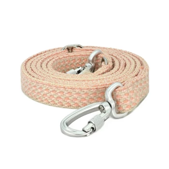 Boho Hundeleine Blush Berry Eine aufgerollte Haustierleine aus weichem rosa und beigem gewebtem Stoff, mit einem stabilen silbernen Metallclip zur Befestigung.