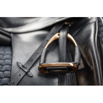 Nahaufnahme eines schwarzen Leder-Sattels mit einem goldenen und schwarzen Steigbügel, der mit "EQUITATE" beschriftet ist, und detaillierter Naht und Polsterung.