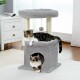 Eine verspielte Katze klettert auf einen natürlichen Sisalpfosten auf einem grauen Katzenbaum, der einen gemütlichen Rückzugsort und ein hängendes Spielzeug bietet, das die Pfotenreinigung fördert.