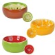 Trois bols pour animaux en forme de fruits : un kiwi brun avec un intérieur vert, une pastèque rouge, et un bol orange vif.