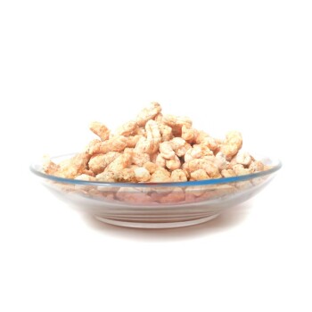 Ein Glasplatte gefüllt mit hellen Haustierleckereien, die wie Puffs aussehen, vor einem weißen Hintergrund.