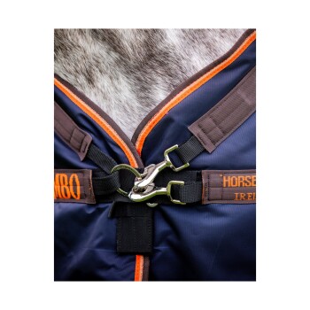 Nahaufnahme einer Pferde-Decke aus marineblauem Stoff mit orangefarbenen und braunen Akzenten, die eine Metall-Schnalle und Riemen zeigt.