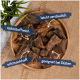 Eine Holzschale mit Haustierleckerlis, beschriftet auf Deutsch: "nährstoffreich", "leicht verdaulich", "schmackhaft" und "geeignet bei Diäten."