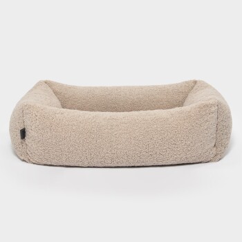 Ein gemütliches beiges Haustierbett mit weichem, flauschigem Stoff und erhöhten Rändern, perfekt für kleine bis mittelgroße Haustiere.