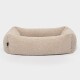 Ein gemütliches beiges Haustierbett mit weichem, flauschigem Stoff und erhöhten Rändern, perfekt für kleine bis mittelgroße Haustiere.