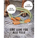 Eine 230 cm lange grüne Hundeleine mit Ledergriffen liegt auf Steinen, neben Hundepfoten. Text: "Eine Leine für alle Felle."