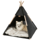 Ein kleiner, flauschiger weißer Hund sitzt bequem in einem dunkelgrauen Haustier-Tipi mit Holzpfosten und ruht auf einer weichen, gemusterten Decke.