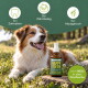 Ein verspielter Hund sitzt auf Gras neben einer Zahnpflegesprayflasche, mit Text: "Entfernt Zahnstein", "Eliminiert Plaque", "Neutralisiert schlechten Atem."