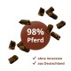 Braune Tierleckerlis um einen Kreis mit Aufschrift '98% Pferd' und zwei Häkchen: ohne Innereien, aus Deutschland.
