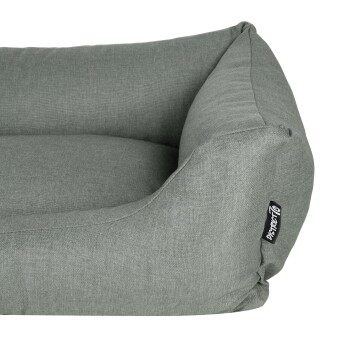 Graues Haustierbett mit weichem, gepolstertem Design und abgerundeten Kanten, mit einem schwarzen Markenschild an der Seite.