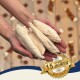 Hände halten mehrere weiße getrocknete Kausnacks; goldene Plakette mit der Aufschrift 'SEIT ÜBER 15 JAHREN' und 'BESTE QUALITÄT'